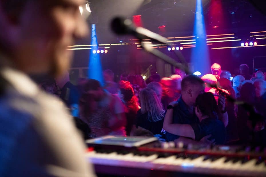 Ett fullt dansgolv, i förgrunden syns en person (Patrich Rundström i Sannex) stå vid sin keyboard.